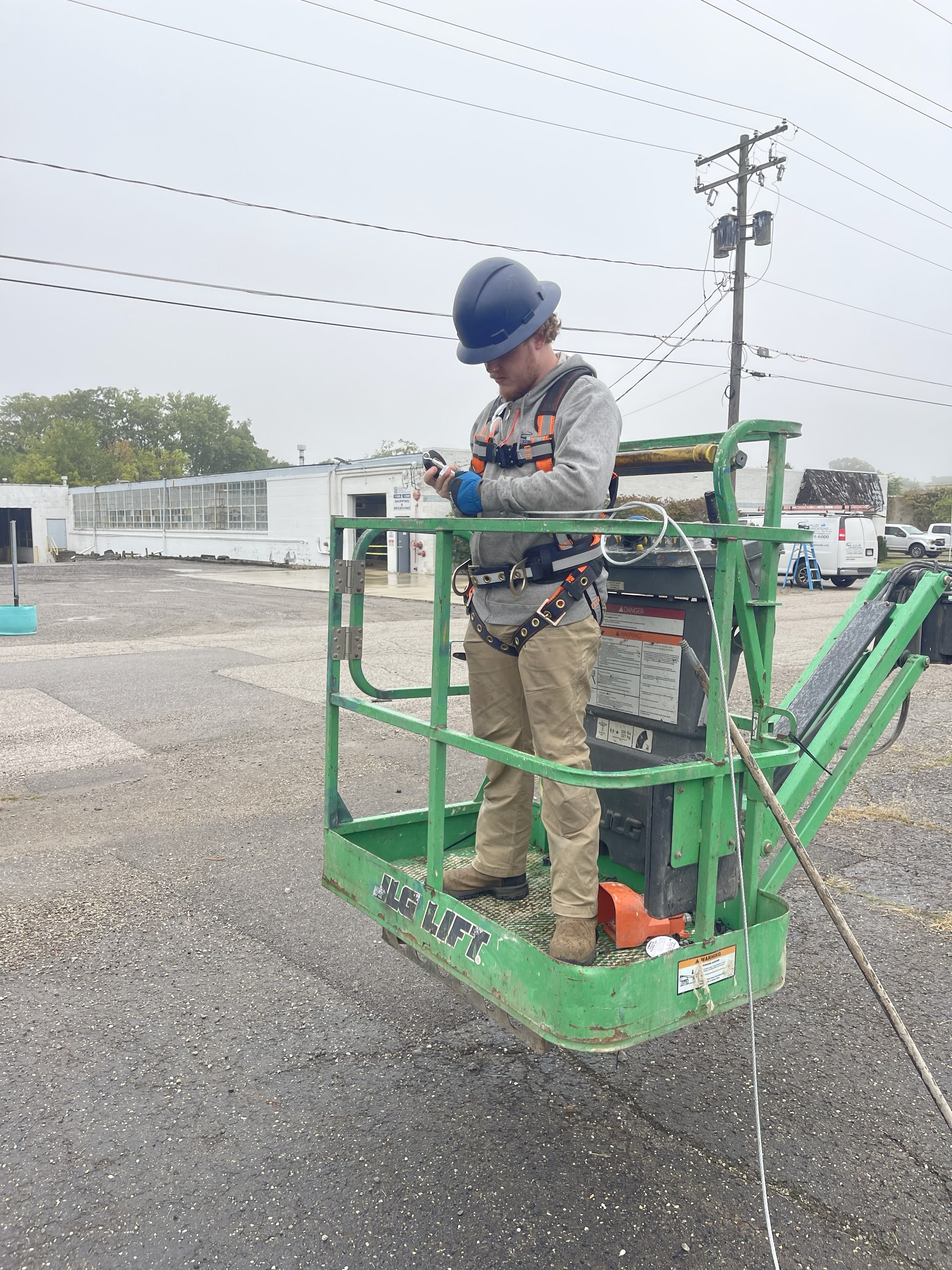 Valley Communications LLC technician in aerial lift performing overhead cabling work