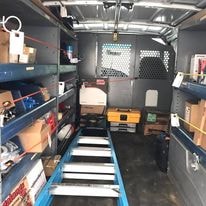 Interior of Valley Communications LLC service van with organized shelving and tools